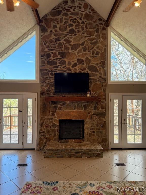 unfurnished living room with high vaulted ceiling, light tile patterned floors, and beamed ceiling