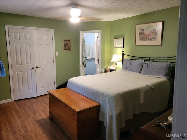 bedroom featuring ceiling fan, dark hardwood / wood-style flooring, a closet, and a textured ceiling