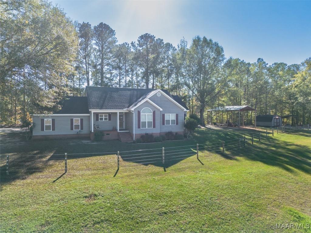 ranch-style home with a carport and a front lawn