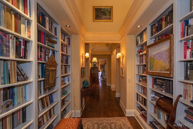 hall with dark hardwood / wood-style flooring, built in shelves, and crown molding