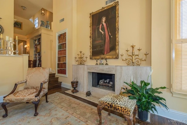 sitting room featuring a premium fireplace and wood-type flooring