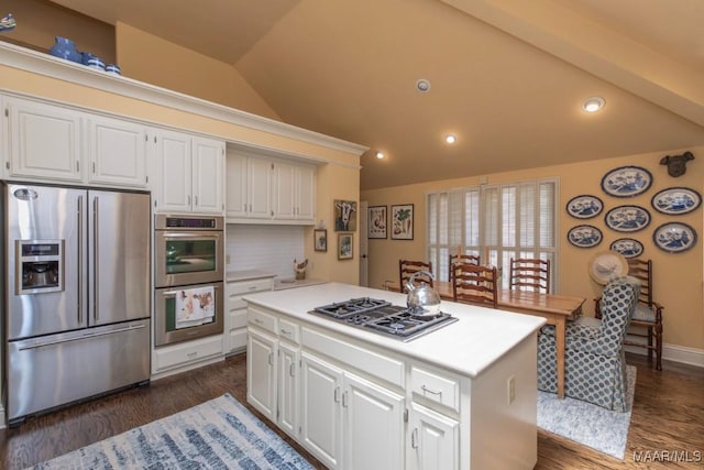 kitchen featuring a kitchen island, white cabinets, tasteful backsplash, and appliances with stainless steel finishes