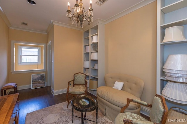 sitting room featuring dark hardwood / wood-style flooring, ornamental molding, and a chandelier