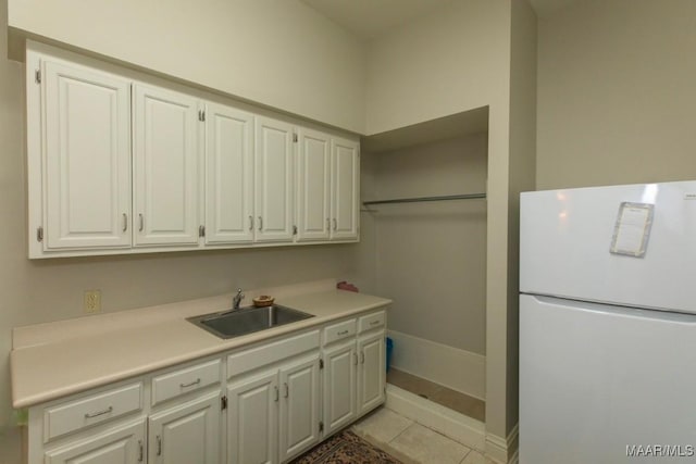 laundry area featuring light tile patterned floors and sink