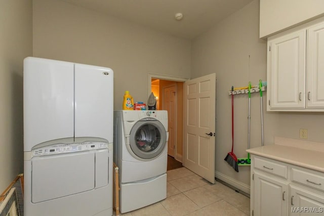 clothes washing area featuring cabinets, independent washer and dryer, and light tile patterned floors