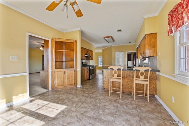 kitchen with kitchen peninsula, gas stove, a kitchen bar, crown molding, and light tile patterned flooring