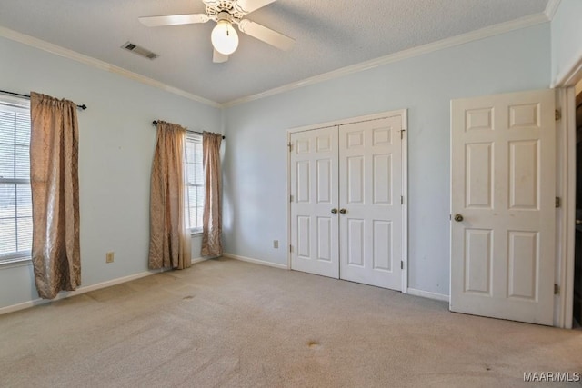 unfurnished bedroom with ceiling fan, light carpet, and multiple windows