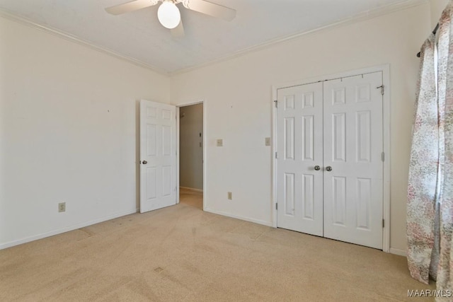 unfurnished bedroom with ceiling fan, light colored carpet, a closet, and crown molding