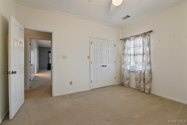 unfurnished bedroom with a closet, ceiling fan, ornamental molding, and light colored carpet