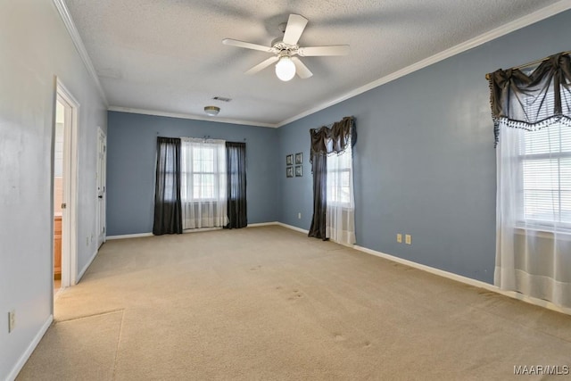 carpeted spare room featuring ceiling fan, crown molding, and a textured ceiling