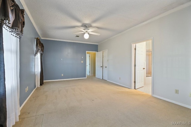 unfurnished bedroom featuring ensuite bath, light colored carpet, ceiling fan, ornamental molding, and a textured ceiling