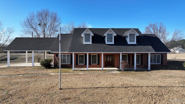 cape cod home with a front yard and covered porch