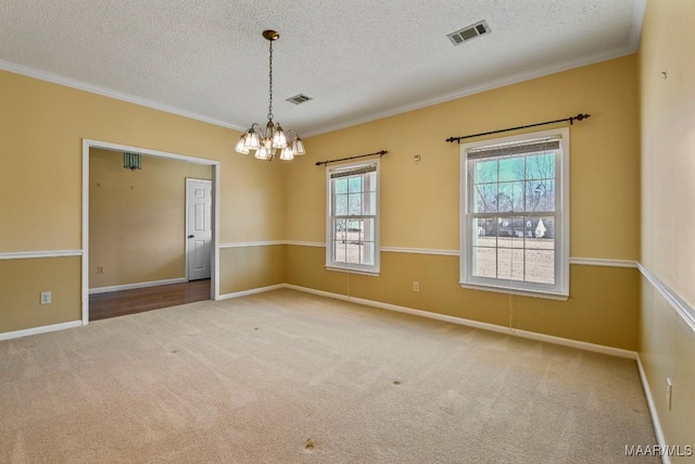 empty room featuring a textured ceiling, crown molding, and carpet flooring