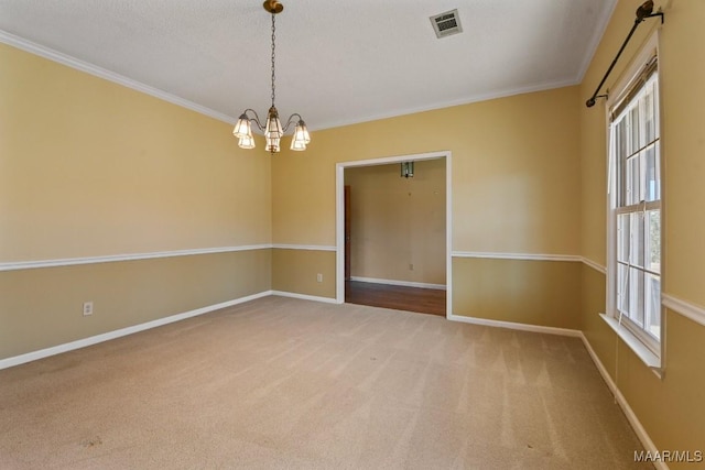 carpeted spare room with a textured ceiling, a chandelier, and crown molding