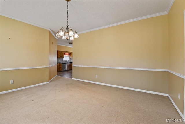 spare room featuring a notable chandelier, a textured ceiling, ornamental molding, and carpet