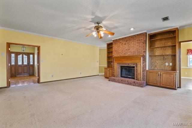 unfurnished living room with a fireplace, a textured ceiling, ceiling fan, and ornamental molding