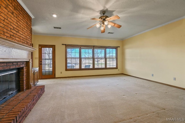 unfurnished living room with a textured ceiling, light colored carpet, crown molding, a fireplace, and ceiling fan