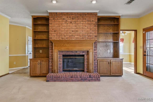 unfurnished living room featuring light carpet, crown molding, ceiling fan, a brick fireplace, and a textured ceiling