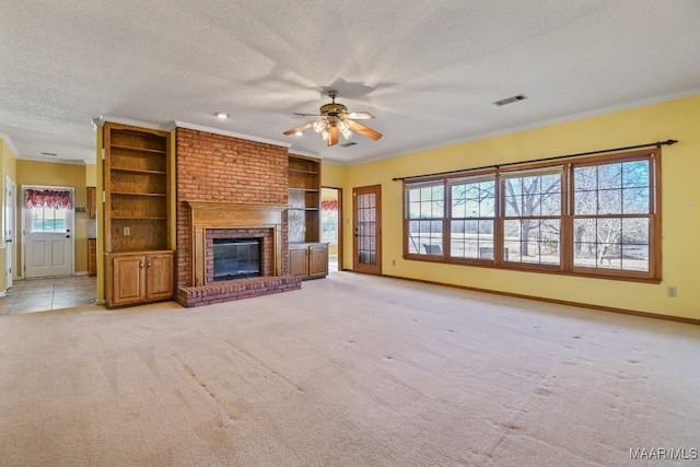 unfurnished living room with a brick fireplace, ceiling fan, ornamental molding, and plenty of natural light