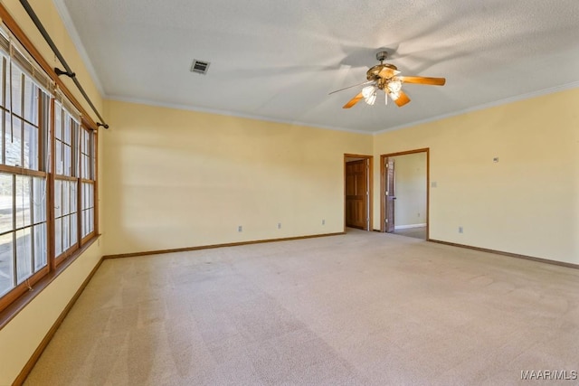 carpeted spare room with a textured ceiling, ornamental molding, and ceiling fan