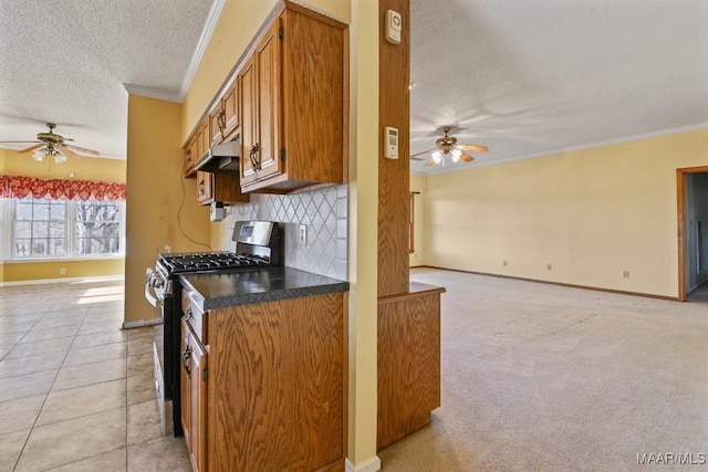 kitchen featuring stainless steel range with gas stovetop, light carpet, crown molding, decorative backsplash, and a textured ceiling