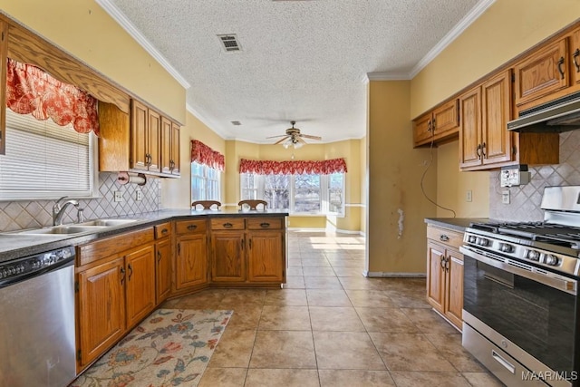 kitchen featuring kitchen peninsula, light tile patterned floors, appliances with stainless steel finishes, ceiling fan, and sink