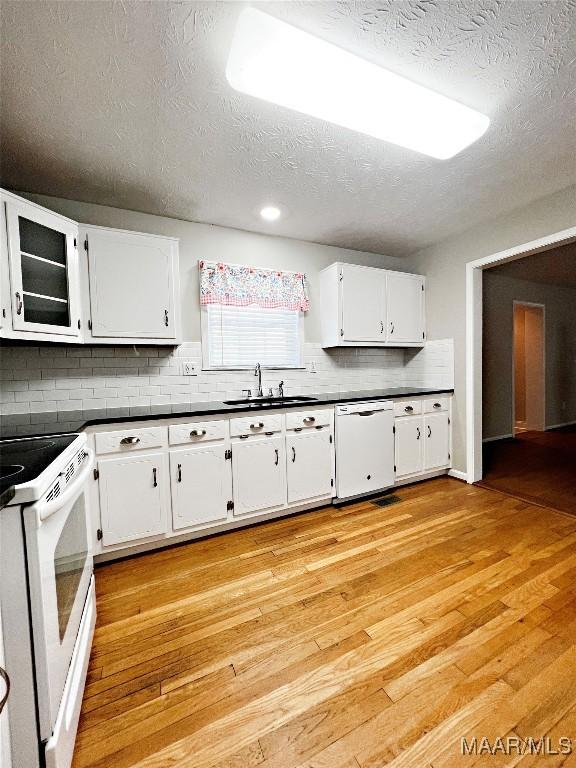 kitchen with sink, white appliances, white cabinetry, and a textured ceiling