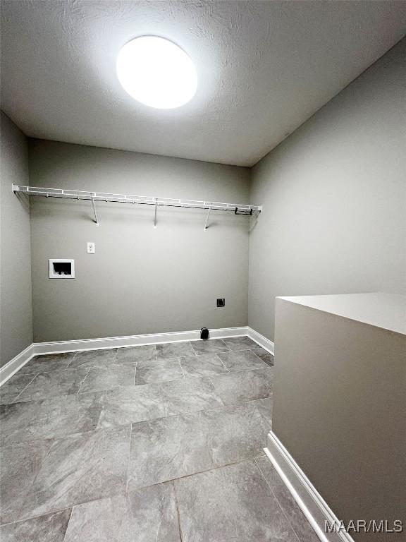 washroom with hookup for a washing machine, hookup for an electric dryer, and a textured ceiling