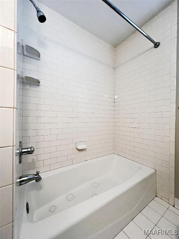 bathroom with tile patterned flooring and tiled shower / bath