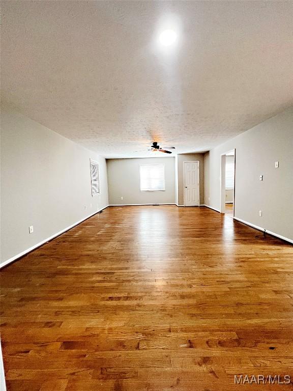 bonus room featuring hardwood / wood-style flooring, a textured ceiling, and ceiling fan