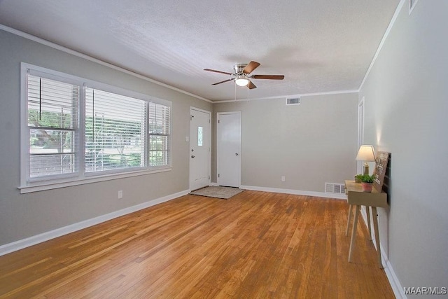 entryway with ceiling fan, crown molding, a textured ceiling, and wood-type flooring