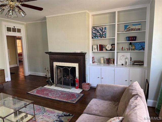 living room featuring ceiling fan, dark hardwood / wood-style floors, built in features, and crown molding