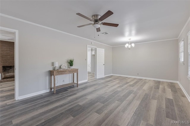 empty room featuring crown molding, baseboards, and wood finished floors