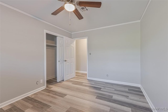 unfurnished bedroom with baseboards, light wood-style flooring, visible vents, and crown molding