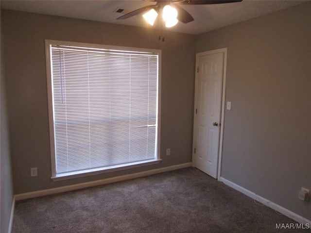 unfurnished room with visible vents, baseboards, carpet floors, and ceiling fan