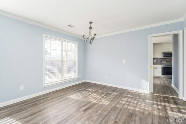 spare room featuring ornamental molding, dark hardwood / wood-style floors, and a chandelier