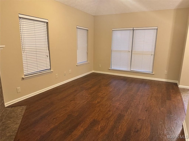 unfurnished room with dark wood-type flooring