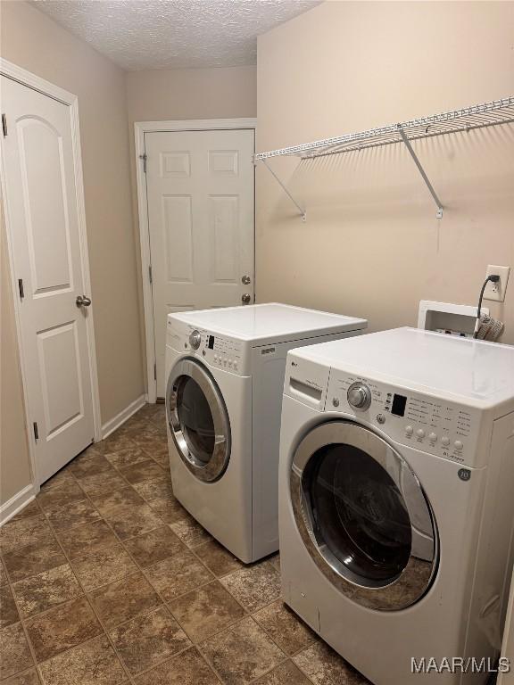 washroom featuring a textured ceiling and washer and dryer