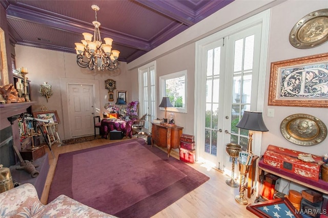 interior space with beam ceiling, an inviting chandelier, crown molding, light wood-type flooring, and french doors