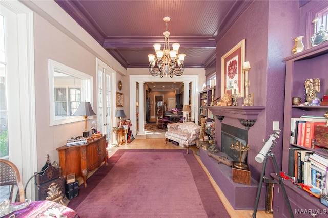 hallway with french doors, crown molding, and a chandelier