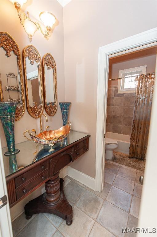 full bathroom with toilet, sink, and shower / bath combo with shower curtain