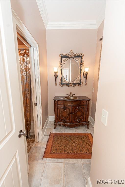 hallway featuring light tile patterned floors, sink, and ornamental molding