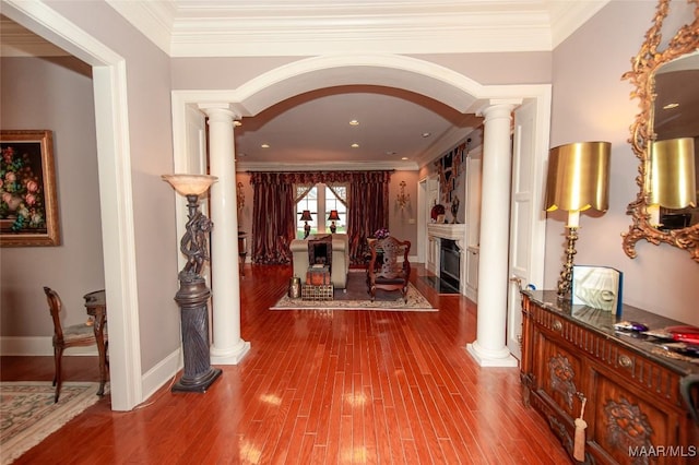 hall featuring decorative columns, crown molding, and hardwood / wood-style floors