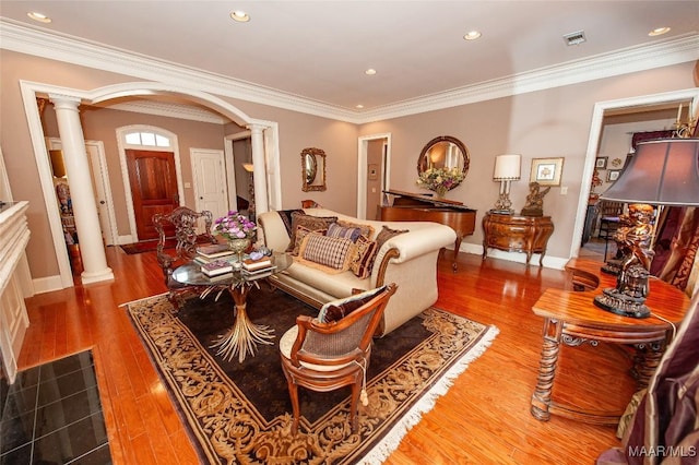 living room featuring crown molding, light hardwood / wood-style flooring, and ornate columns