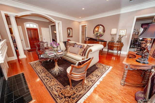 living room with decorative columns, light hardwood / wood-style floors, and ornamental molding