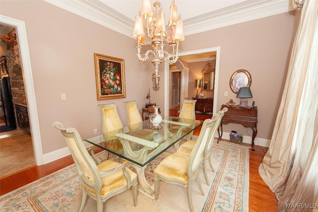 dining area featuring light wood-type flooring, an inviting chandelier, and crown molding