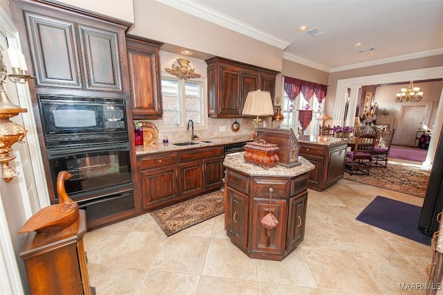 kitchen featuring black appliances, a kitchen island, sink, a chandelier, and light stone counters