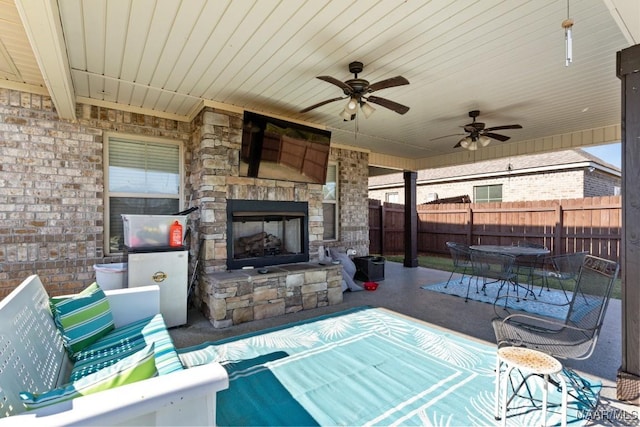 view of patio featuring ceiling fan and an outdoor stone fireplace