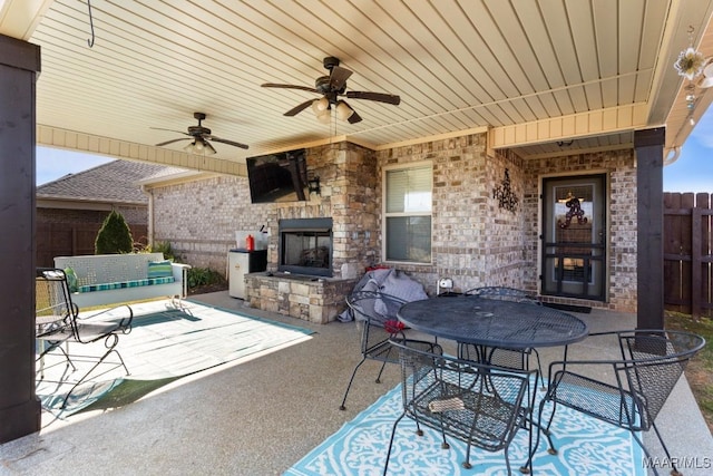 view of patio with ceiling fan and an outdoor stone fireplace