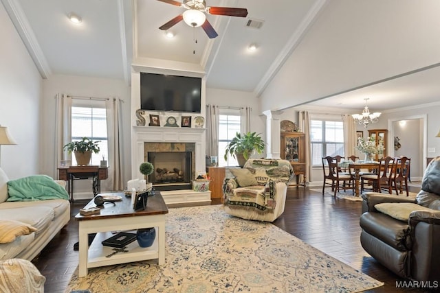 living room with ceiling fan with notable chandelier, dark hardwood / wood-style flooring, crown molding, and a healthy amount of sunlight